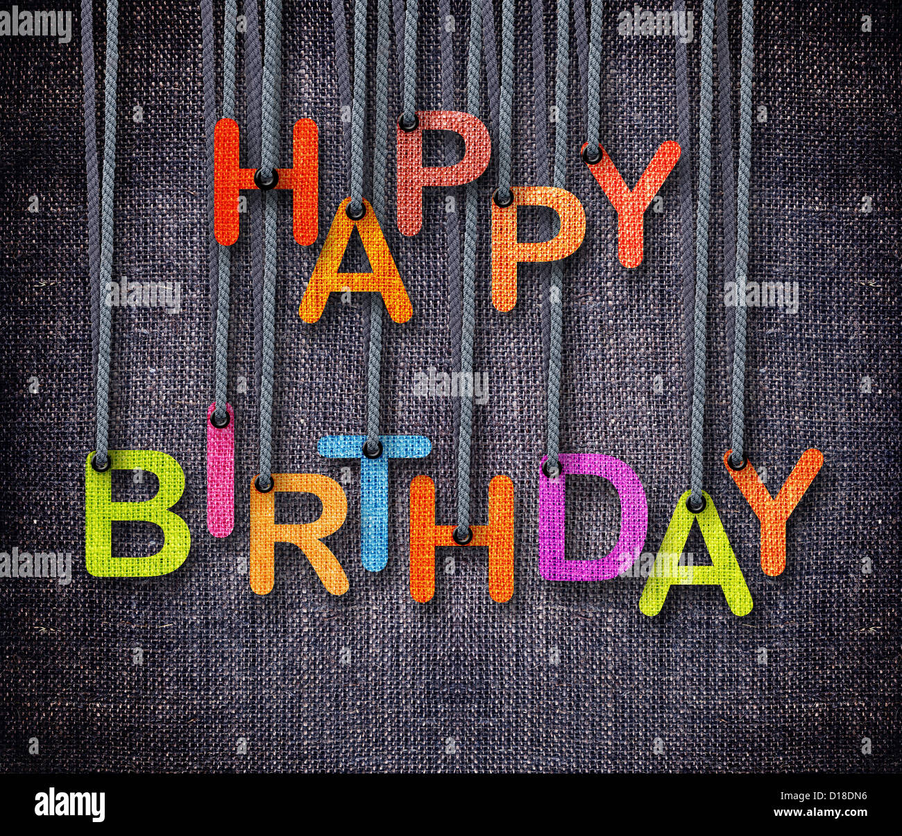 Happy Birthday hanging by rope as puppeteer on sackcloth background. Stock Photo