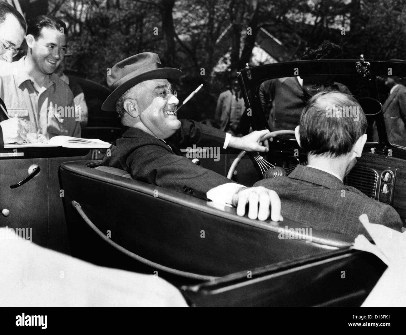 President Franklin Roosevelt, debonair with his cigarette holder. He is at the wheel of his customized auto in 1939. Stock Photo