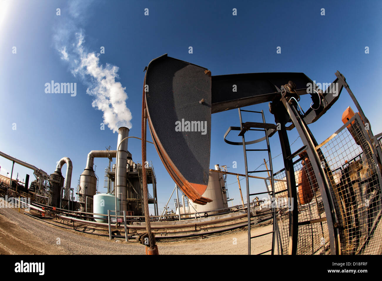 Oil pump and smoke stack in oil field Stock Photo