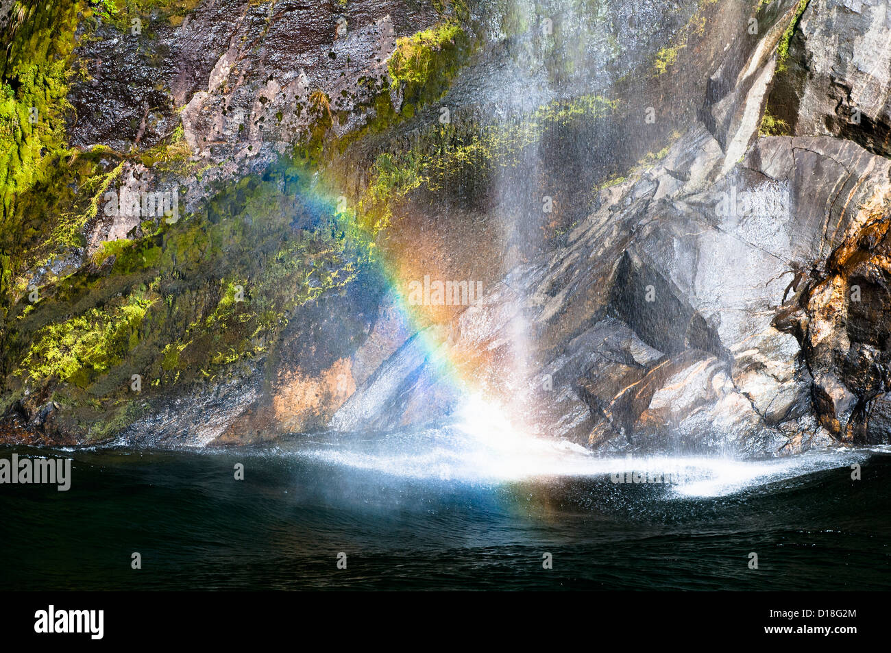 Rainbow in waterfall over cliffs Stock Photo