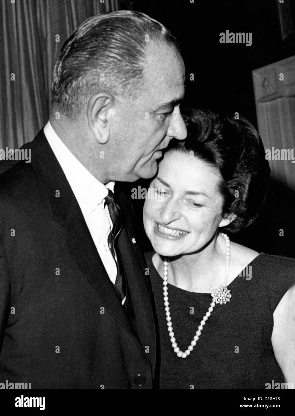 President Lyndon Johnson kisses his wife Lady Bird as they greet guests at the White House. He was hosting a dinner of the Stock Photo