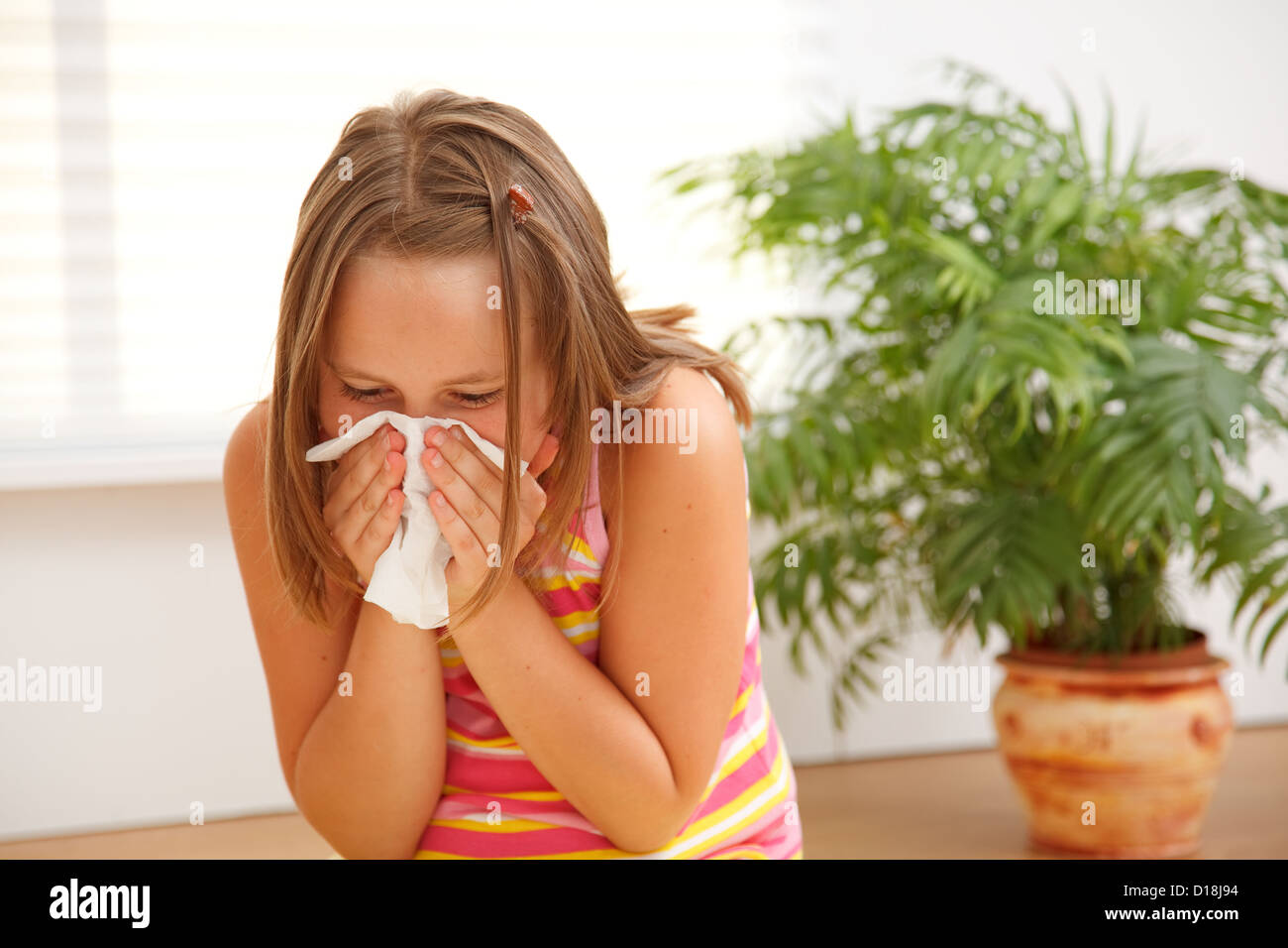 Teen girl blowing out her nose because of allergic reaction on plants Stock Photo