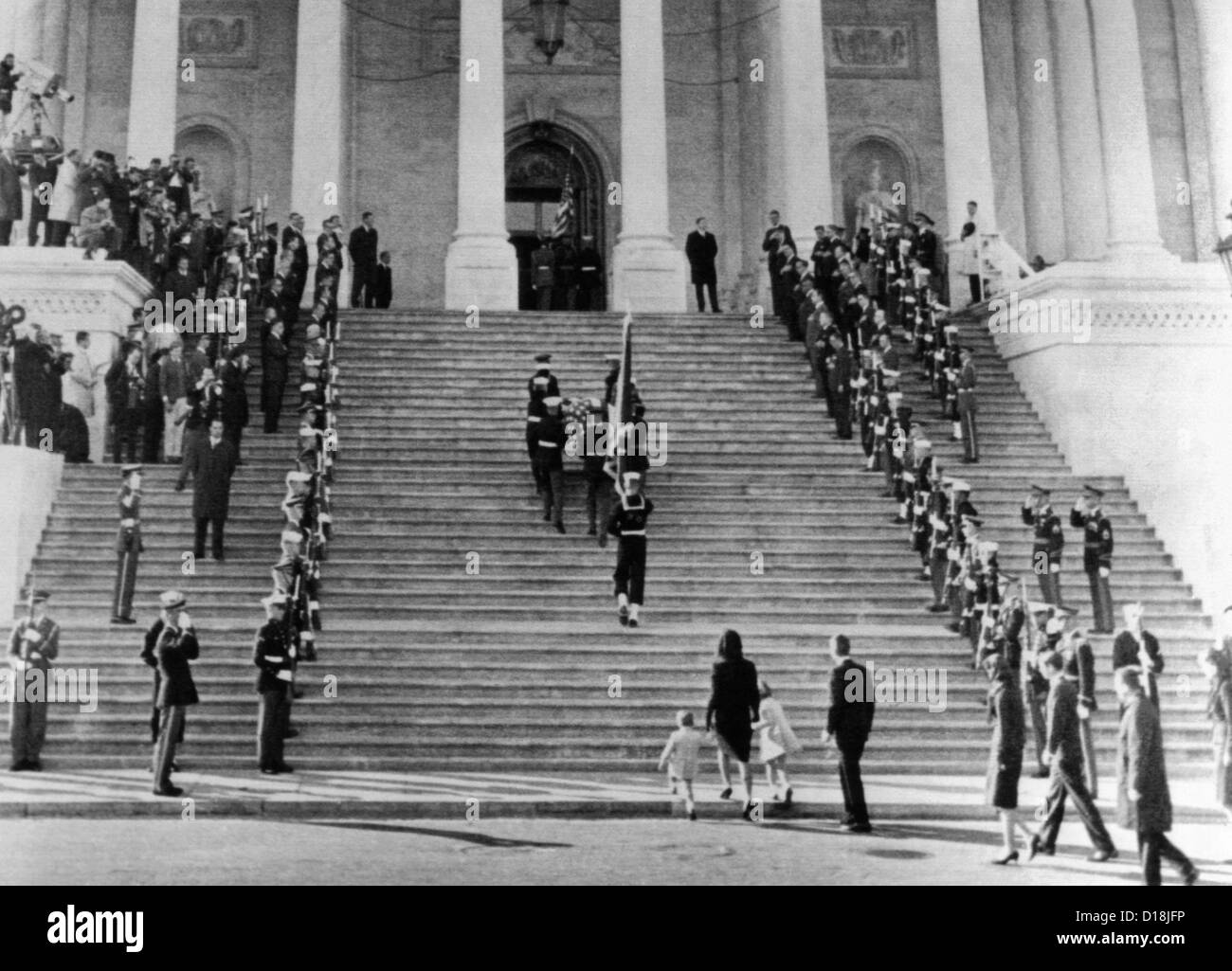 Jacqueline Kennedy escorts her children, Caroline and John, Jr. up the steps of the Capitol. They are following the casket of Stock Photo