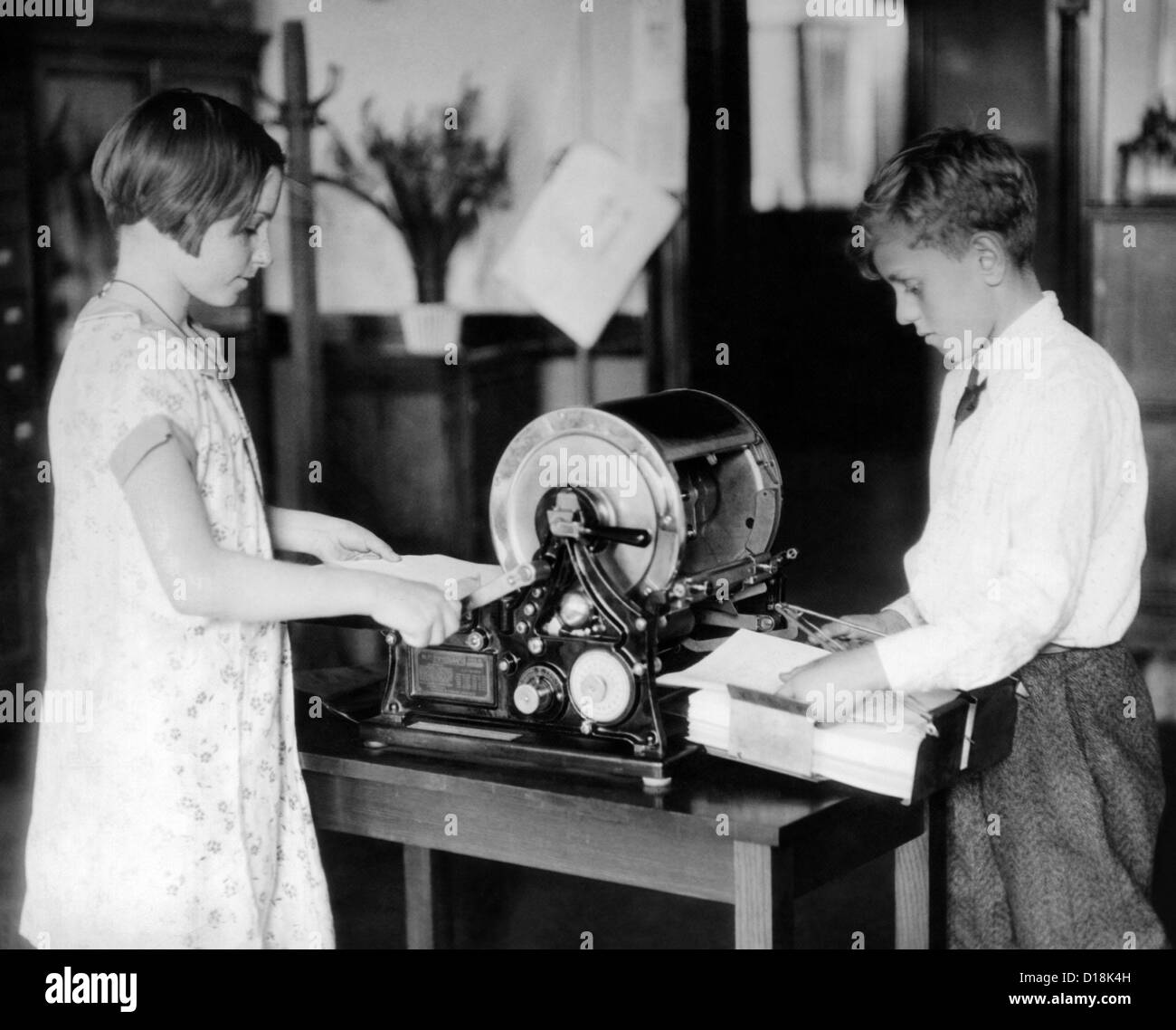 School children work on a mimeograph machine. Thomas Edison had two patents for an 'Autographic Printing' that worked by Stock Photo