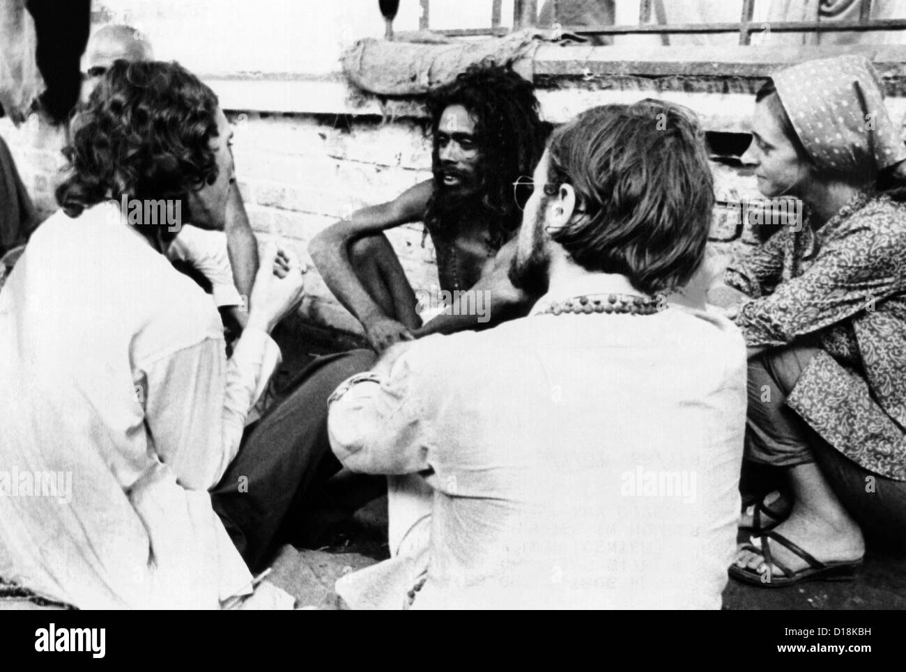 American hippies in Katmandu, Nepal. They talk with an Indian Sadhu, a Hindu Holy man, on a rooftop. The hippie community in Stock Photo