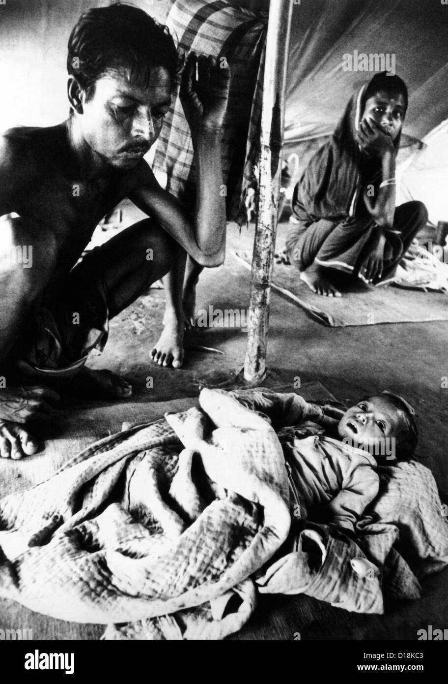 Father's vigil over his dying son in a refugee camp during the Bangladesh Liberation War in 1971. They are part of the 9.5 Stock Photo