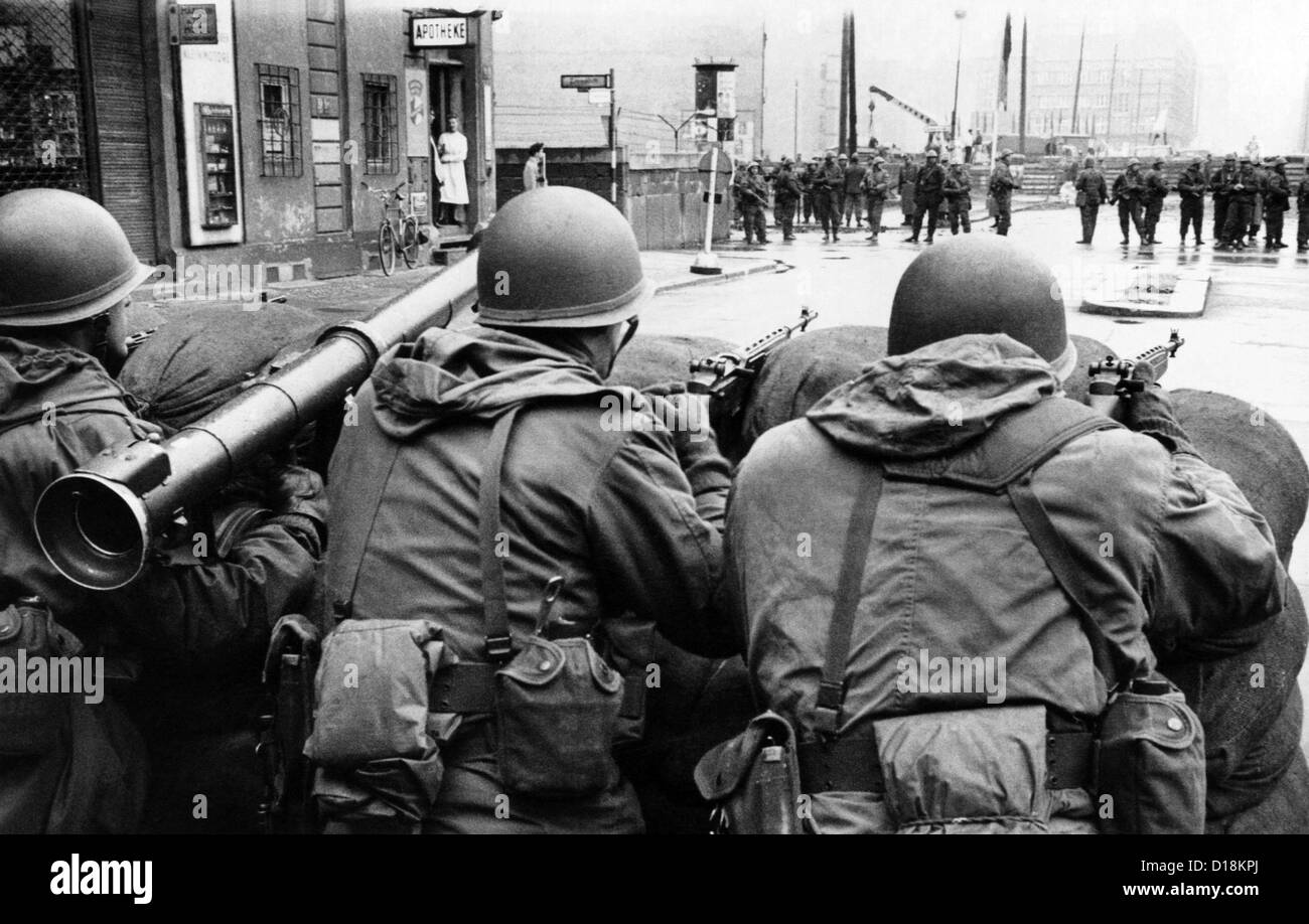American troops face East Berlin behind sandbags at Checkpoint Charlie at Friedrichstrasse in West Berlin.  In the distance are Stock Photo