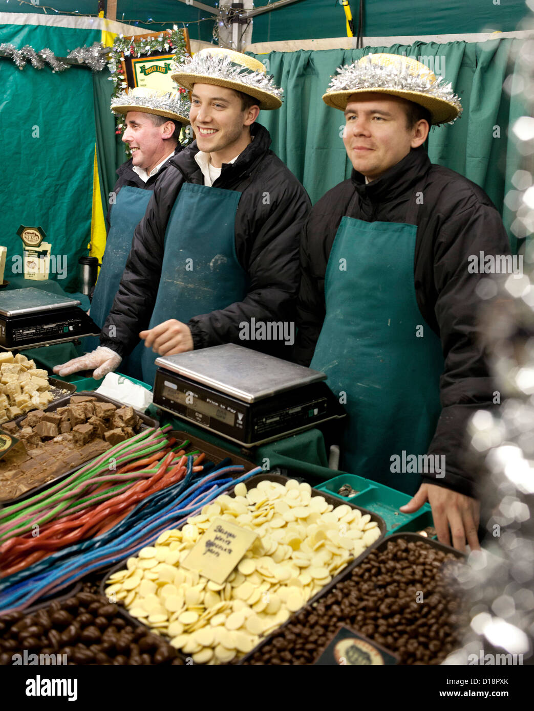 The annual Christmas market in Lincoln, England, UK. Three men selling sweets and chocolates on one of the stalls. Stock Photo