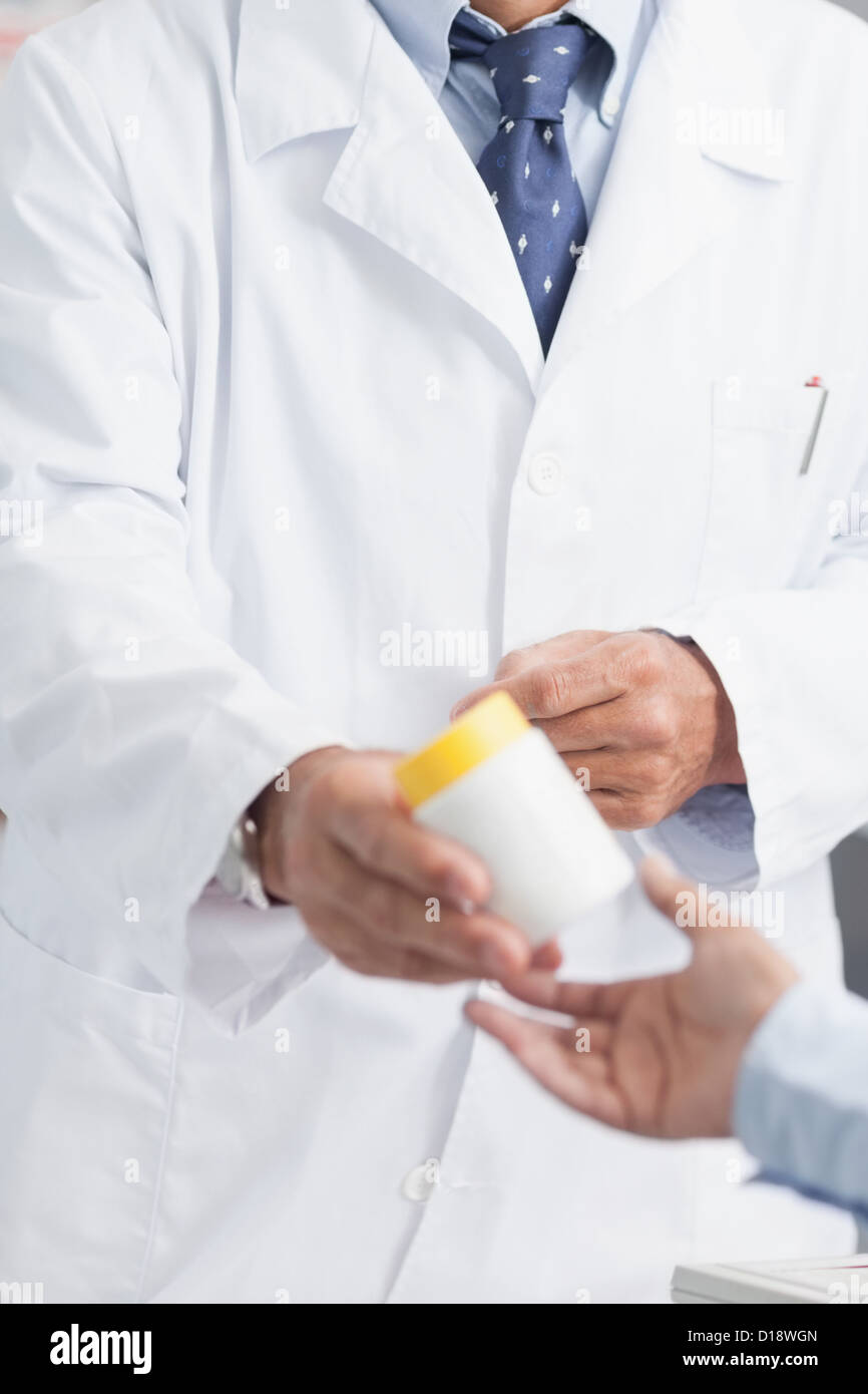 Pharmacist giving a box of pills to someone Stock Photo