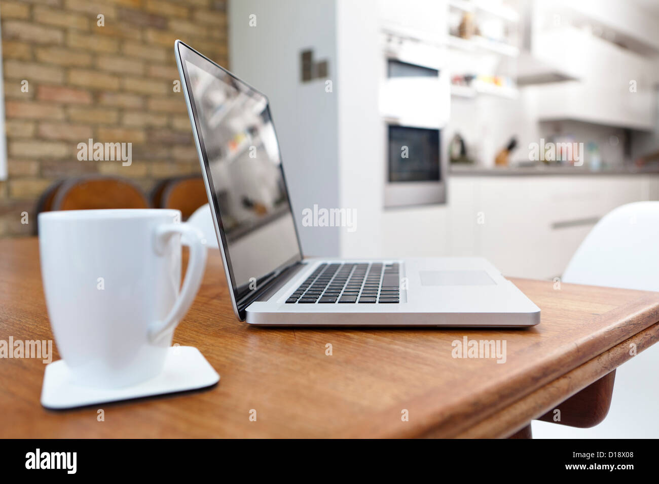 Laptop and mug on table Stock Photo