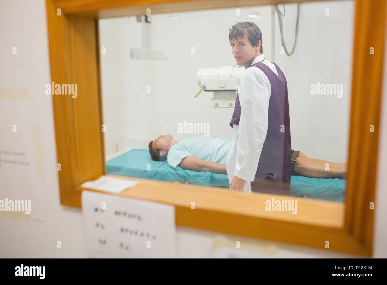 View of practitioner doing a radiography through a window Stock Photo