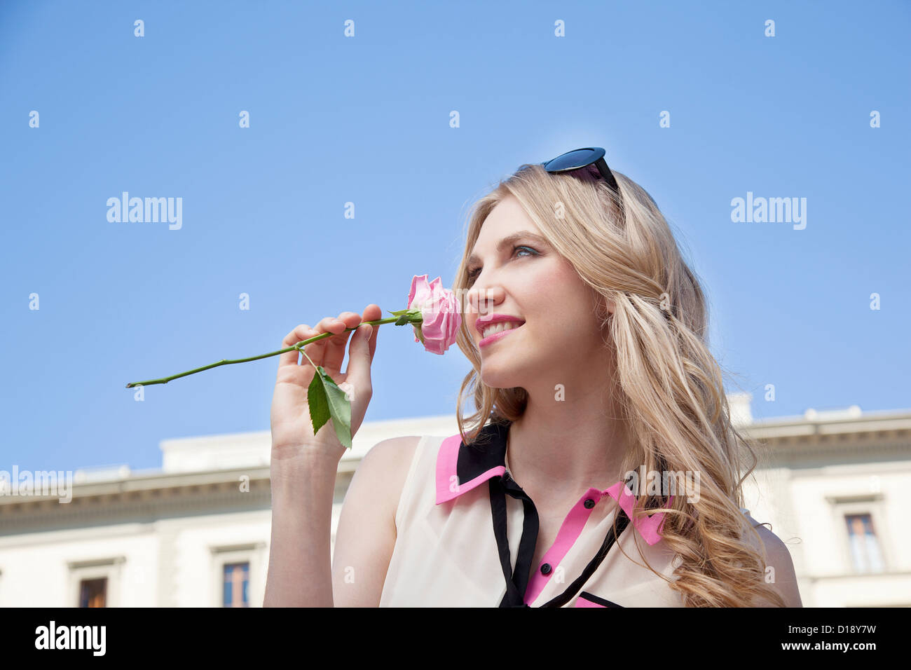 Young woman outdoors smelling rose Stock Photo - Alamy