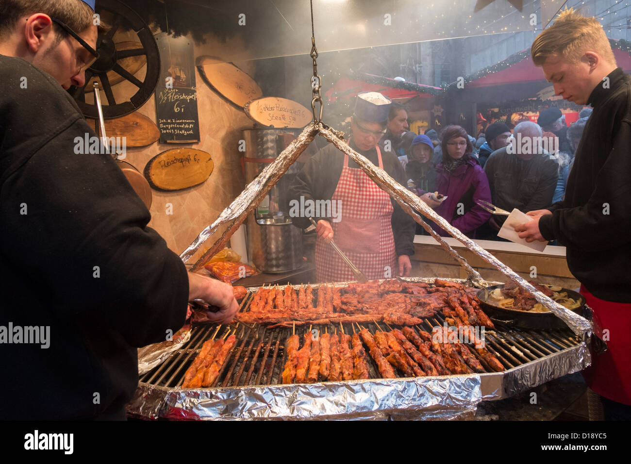 Grilling meat at food stall at Christmas market in Cologne Germany Stock Photo