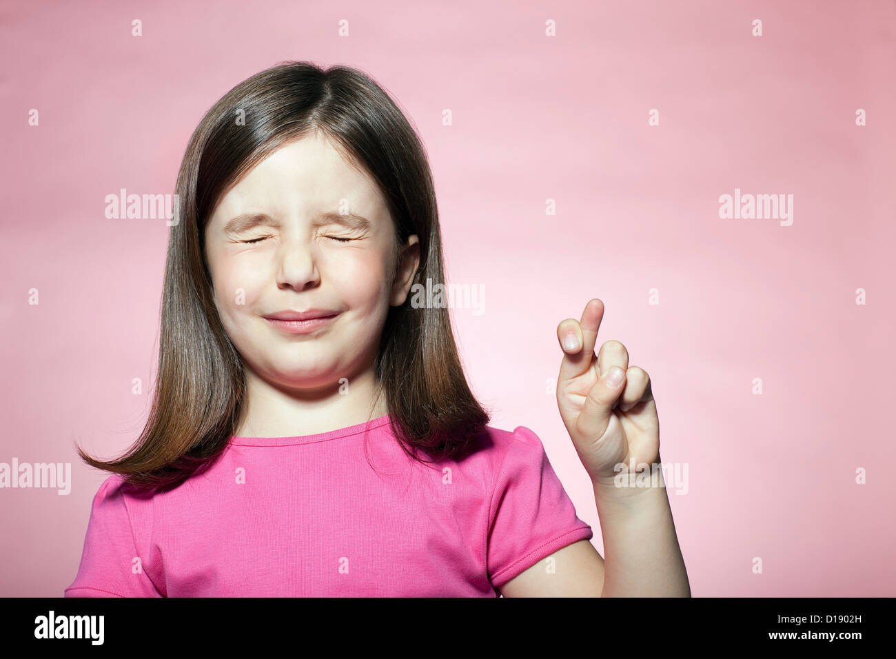 Girl with fingers crossed Stock Photo - Alamy