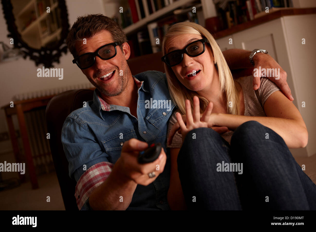 Couple wearing 3d glasses watching tv Stock Photo