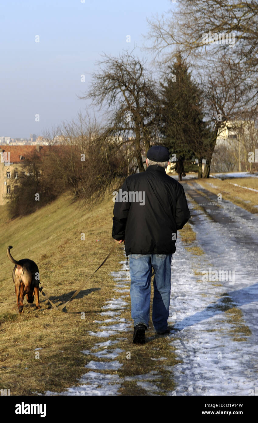 Lithuania. Man walking with his dog on an icy path. Stock Photo