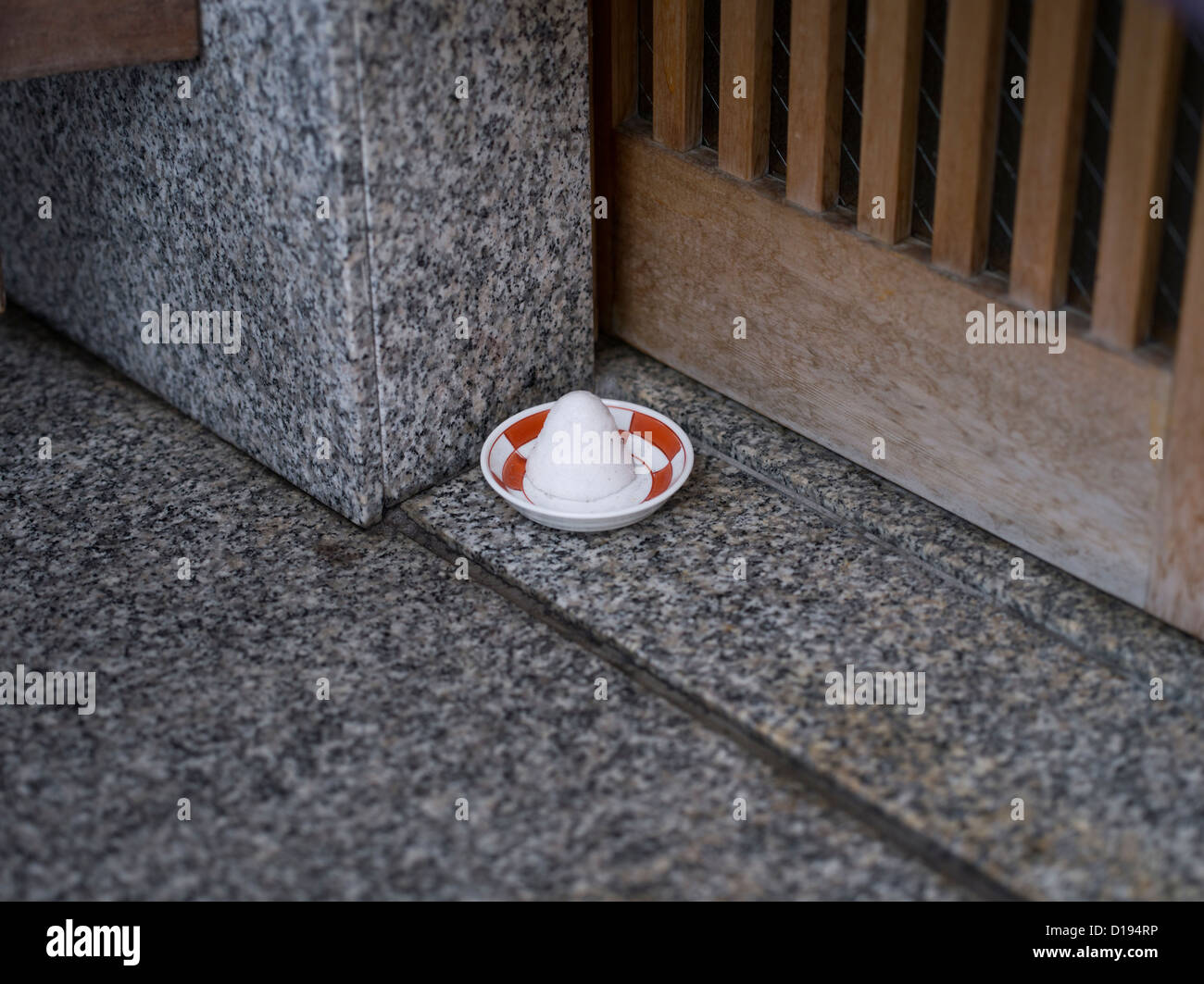 A bowl of salt placed outside the doorway of a Japanese home in Kyoto to ward off evil spirits.  Morijio, or mori-shio (盛塩) Stock Photo
