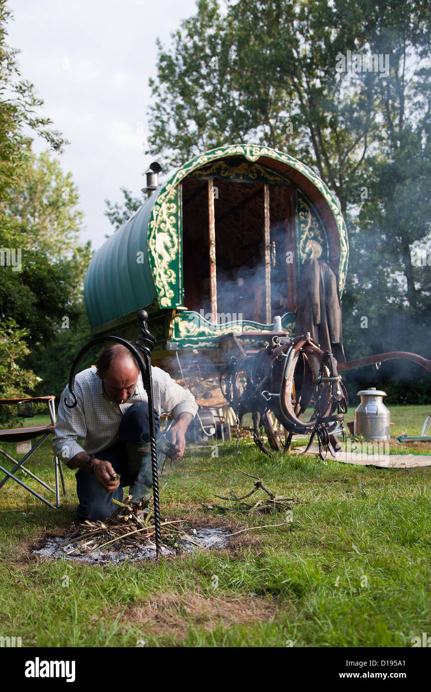 Romany gypsy tending camp fire Stock Photo