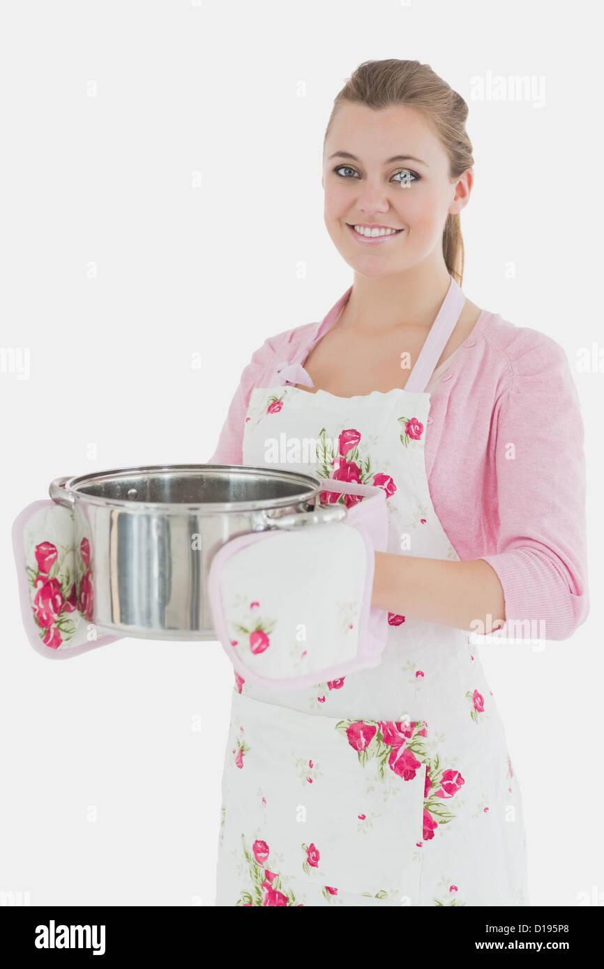 Maid in apron holding kitchen utensil Stock Photo