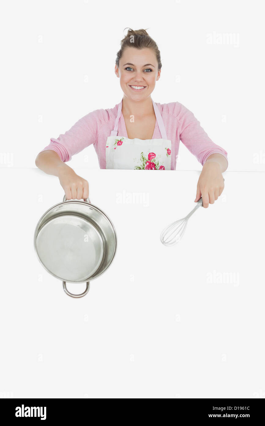 Woman with wire whisk and mixing bowl behind billboard Stock Photo