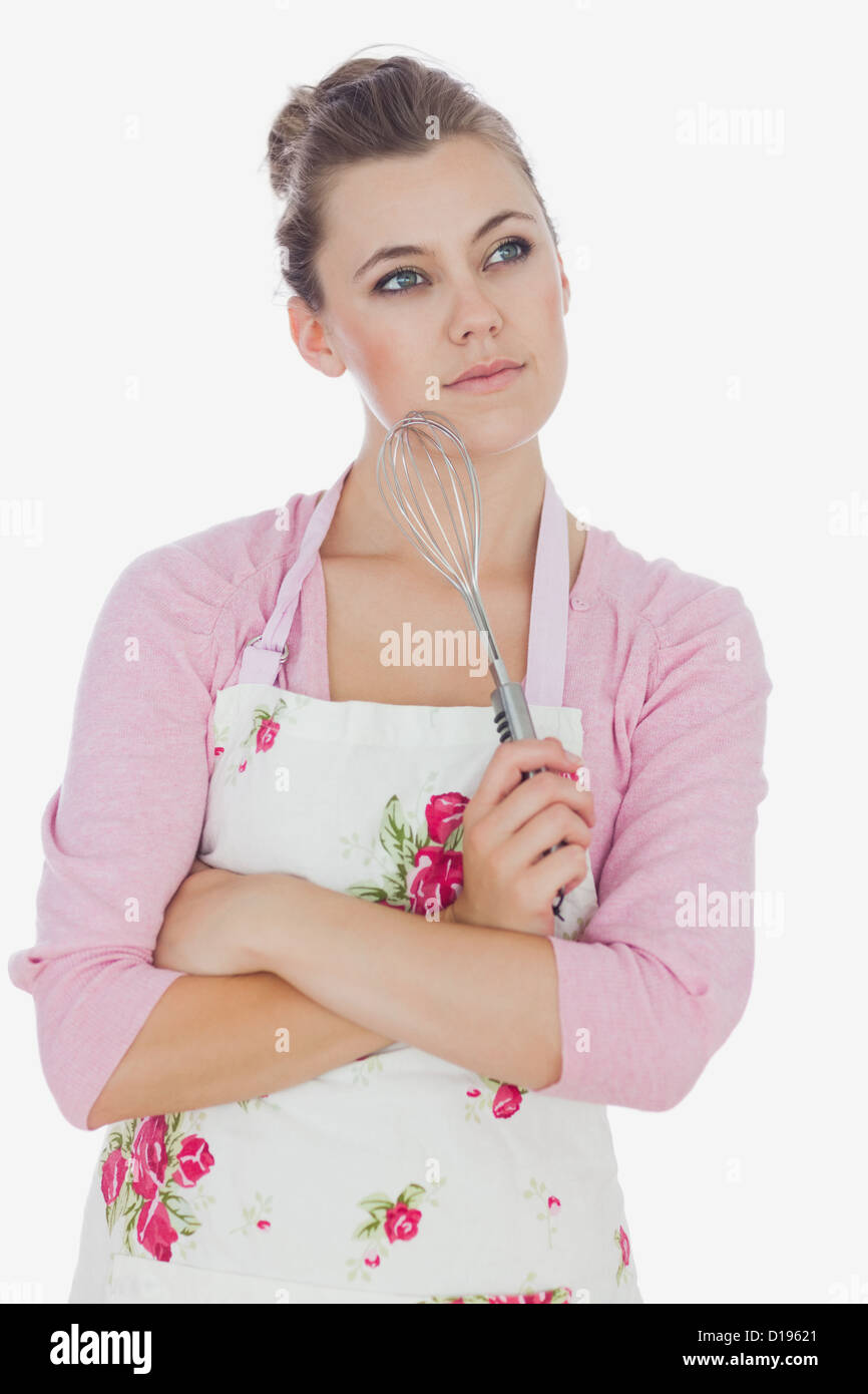 Thoughtful maid holding wire whisk Stock Photo