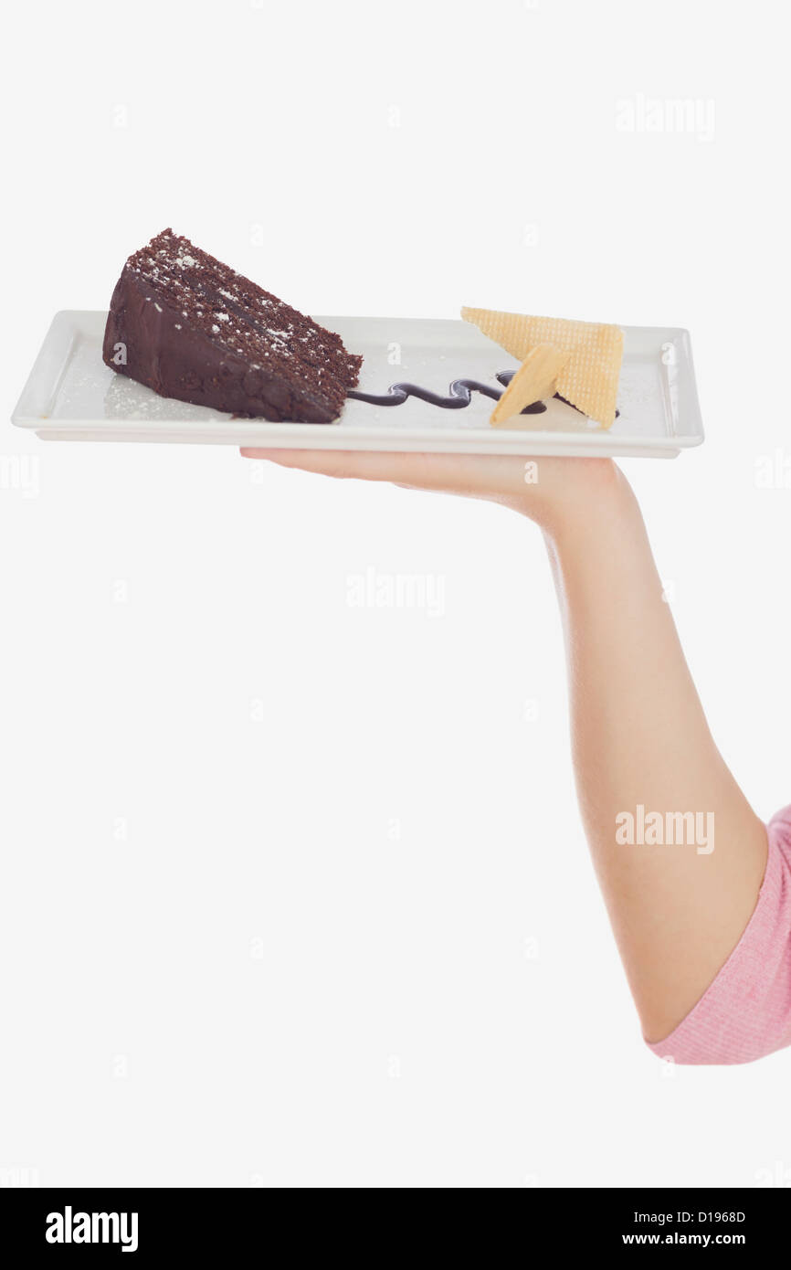 Hand holding plate of tempting pastry Stock Photo