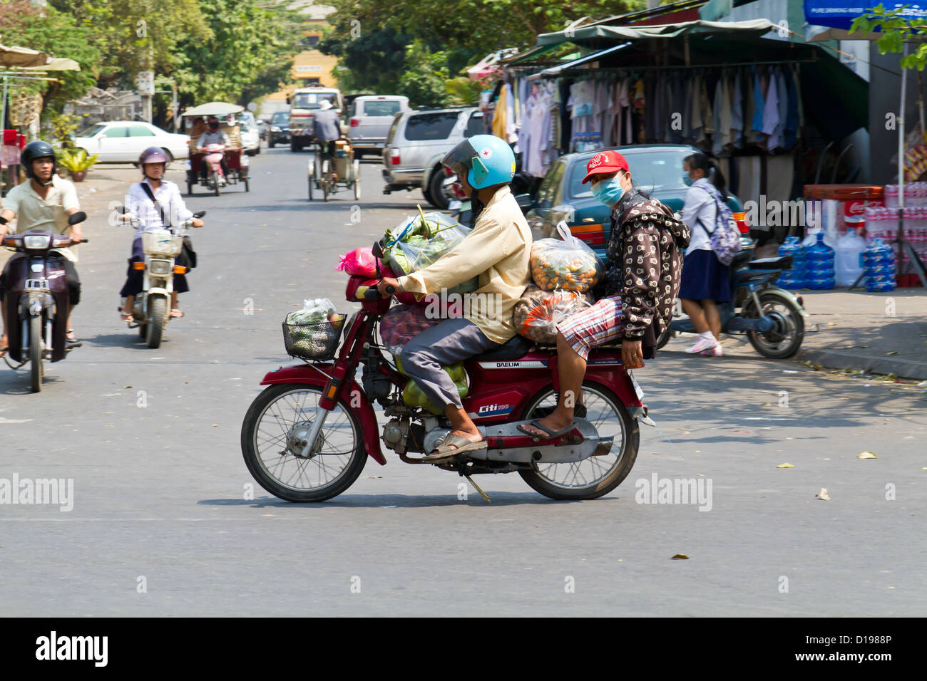 A Cambodian girl is sqeezed between a driver and a passenger of an  overloaded motorbike taxi in the capital Phnom Penh, Tuesday, April 4,  2006. Overloaded motorcycles and cars are a common