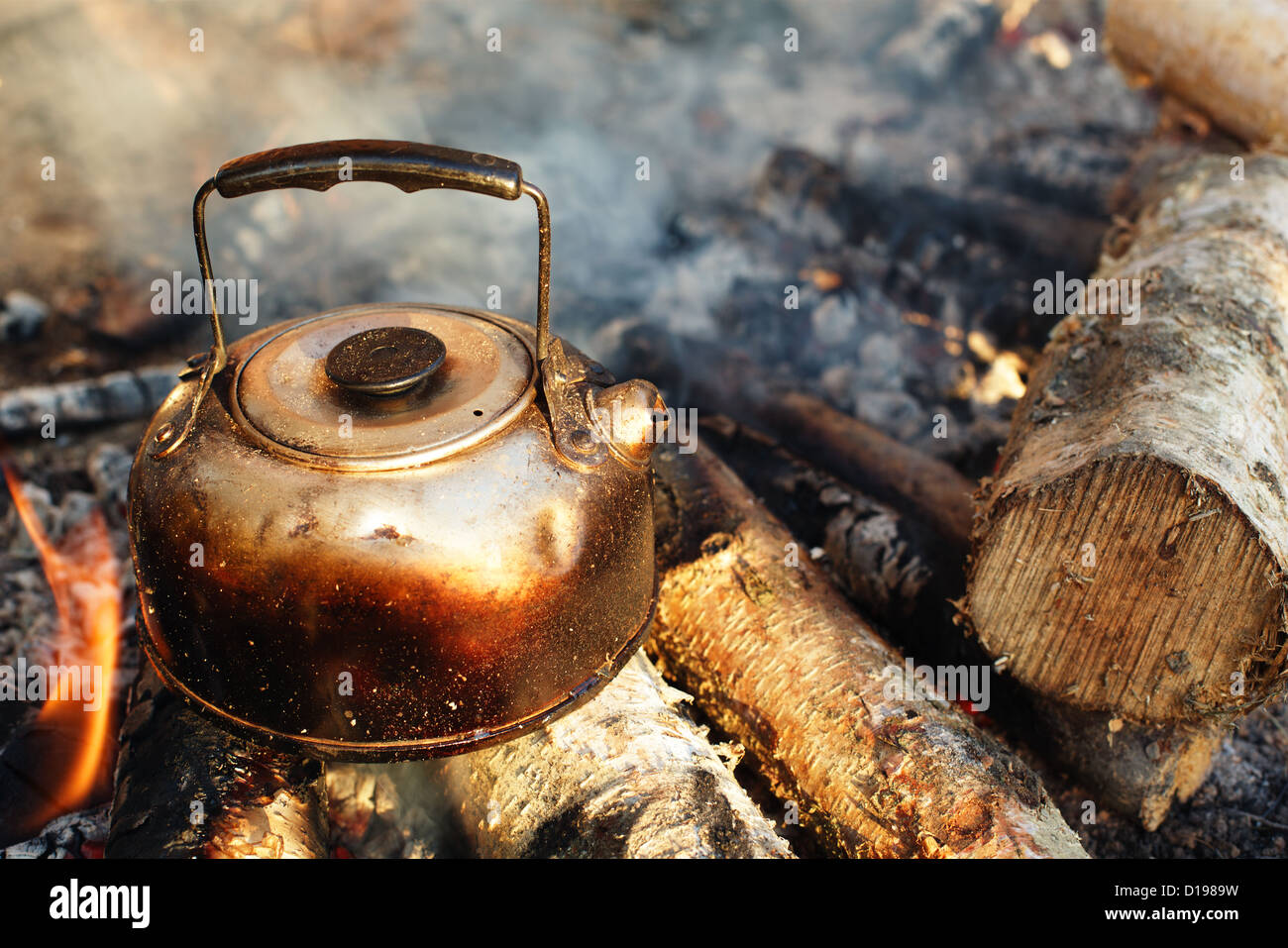 https://c8.alamy.com/comp/D1989W/sooty-teapot-on-camping-bonfire-D1989W.jpg