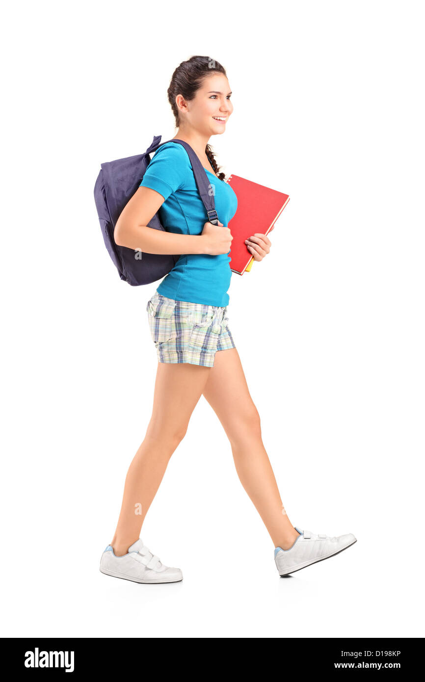 Full length portrait of a female student with backpack walking and