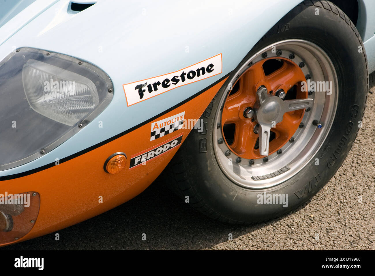 The front wheel of a Gulf coloured Ford GT40 race car. Stock Photo