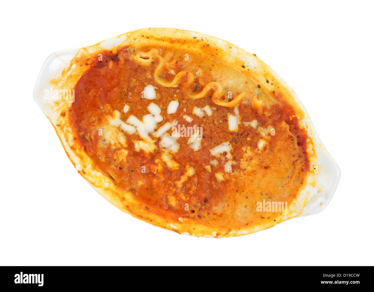 Top view of a small serving of microwaved lasagna in a baking dish with tomato sauce around the rim on a white background. Stock Photo