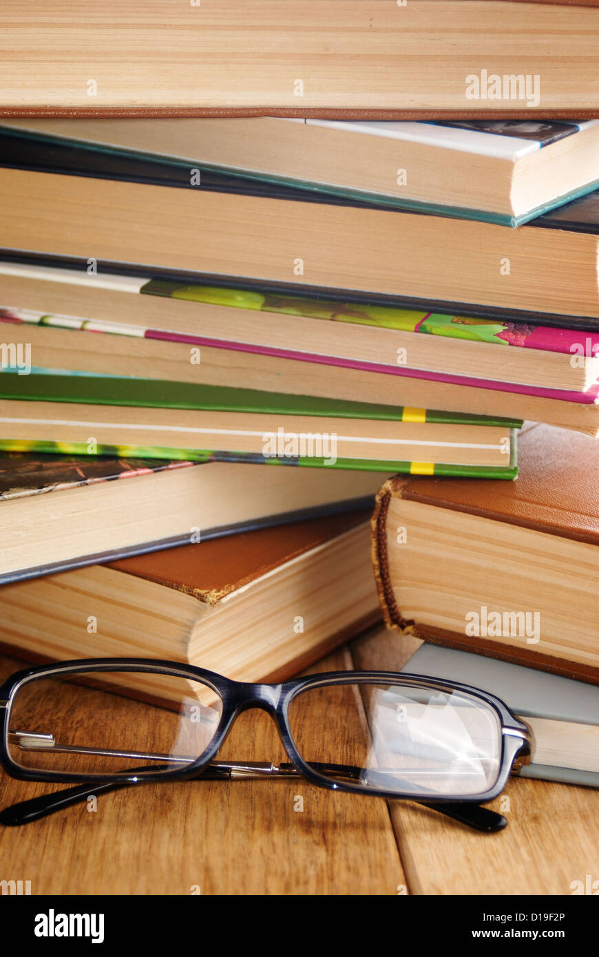 Reading glasses on the opened book on the wooden table Stock Photo - Alamy