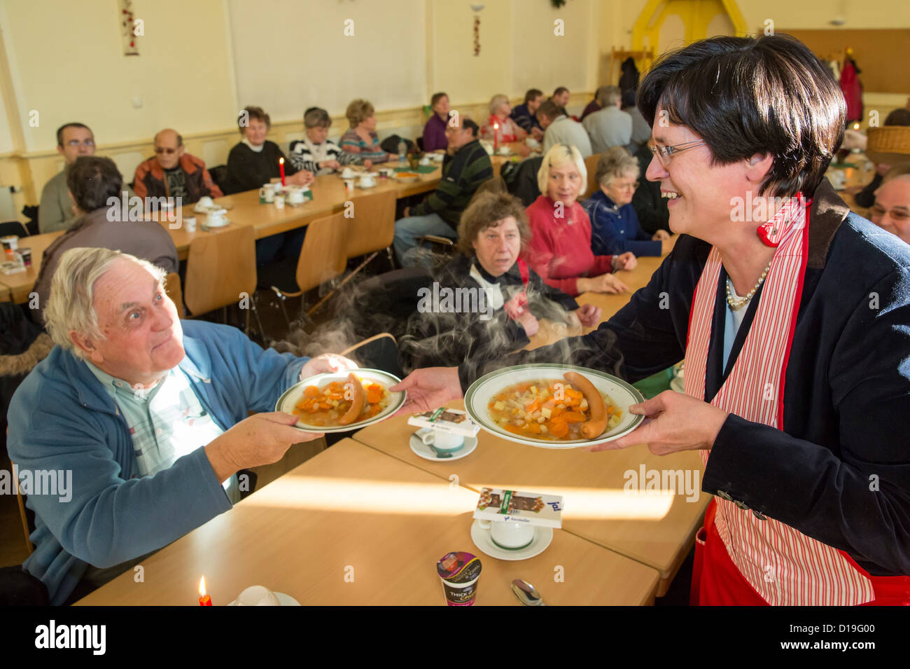 Premier of Thuringia Christine Lieberknecht serves food to the needy at the 'Restaurant des Herzens' (Restaurant of the Heart) in Erfurt, Germany, 11 December 2012. Up to 220 people in need can recieve warm meals hear on workdays until 06 February. Photo: Michael Reichel Stock Photo