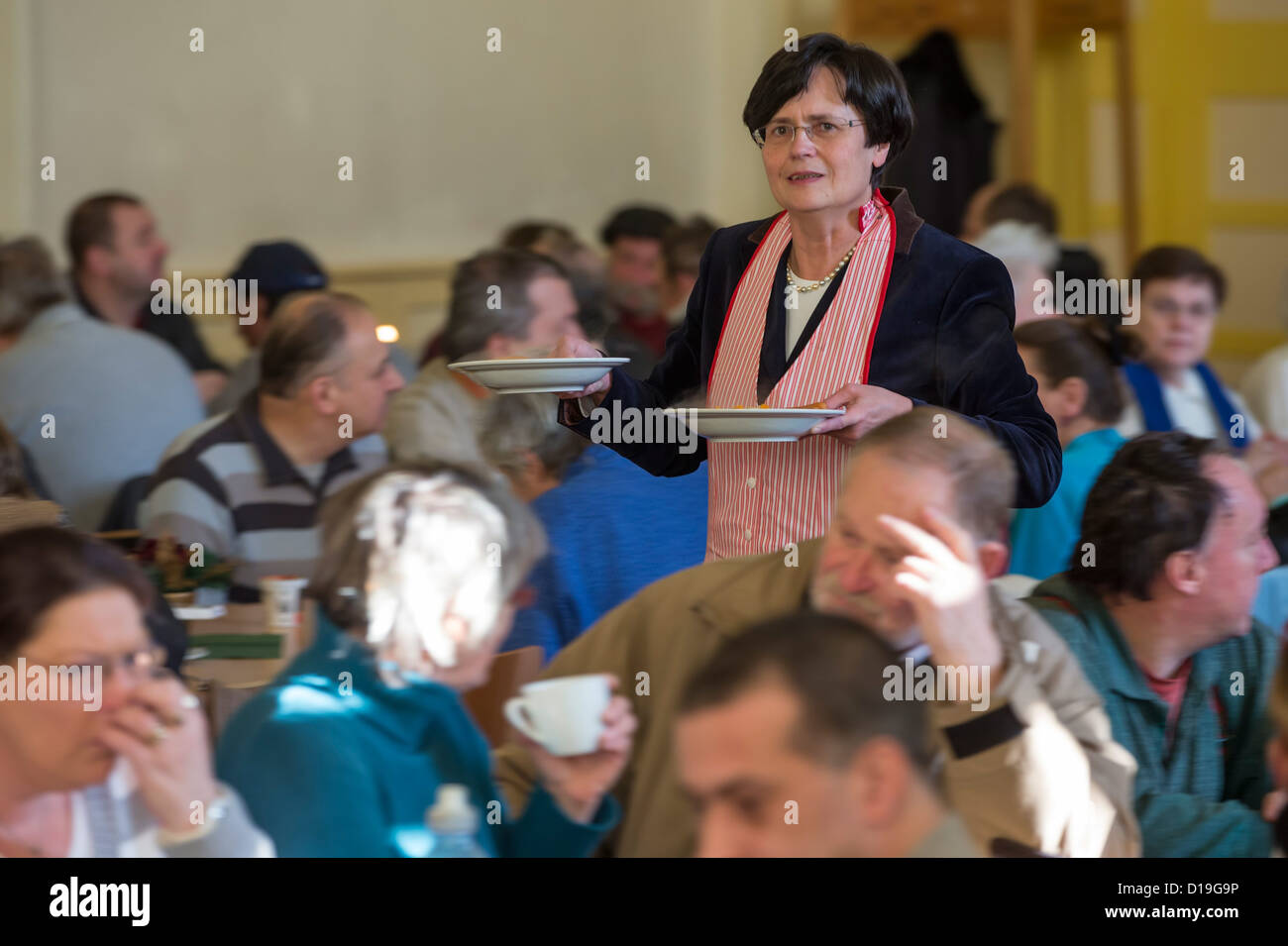 Premier of Thuringia Christine Lieberknecht serves food to the needy at the 'Restaurant des Herzens' (Restaurant of the Heart) in Erfurt, Germany, 11 December 2012. Up to 220 people in need can recieve warm meals hear on workdays until 06 February. Photo: Michael Reichel Stock Photo