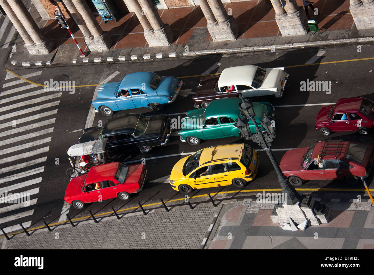 Bright-coloured cars lined up at traffic lights in Havana, Cuba Stock Photo