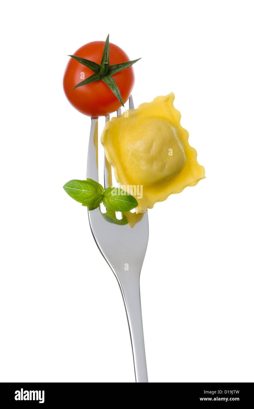 ravioli pasta tomato and basil on a fork against white background. healthy mediterranean diet concept Stock Photo
