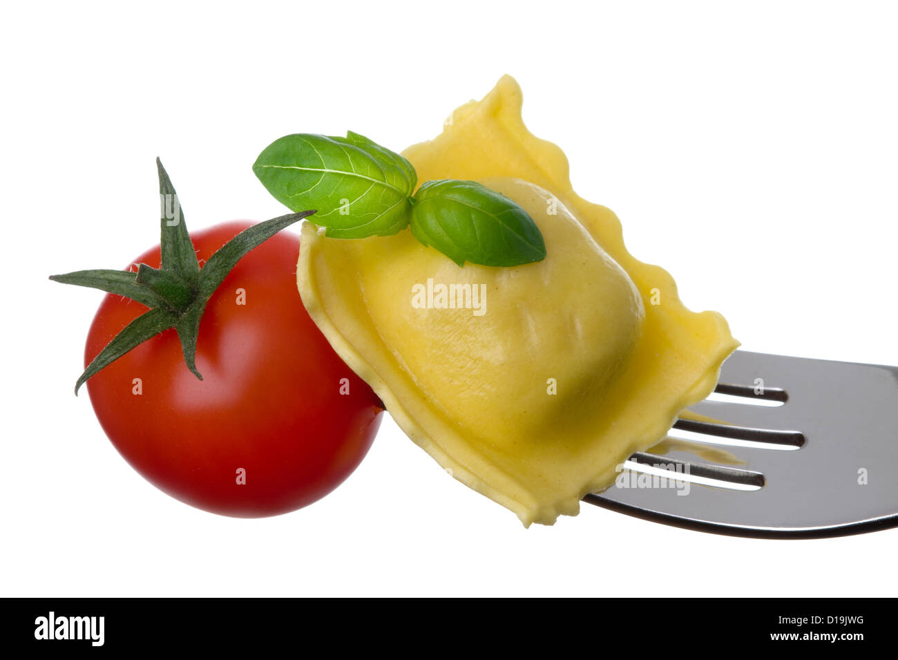 italian food or cuisine of ravioli pasta tomato and basil on a fork against white background Stock Photo