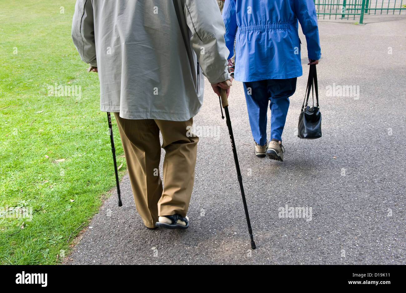 An old woman and a man walking with a walking stick Stock Photo