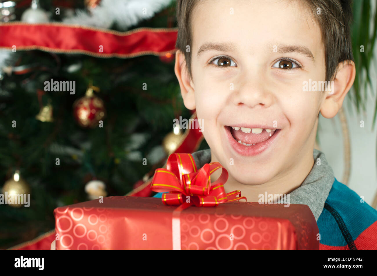 Happy child receive the gift of Christmas in front of the Christmas