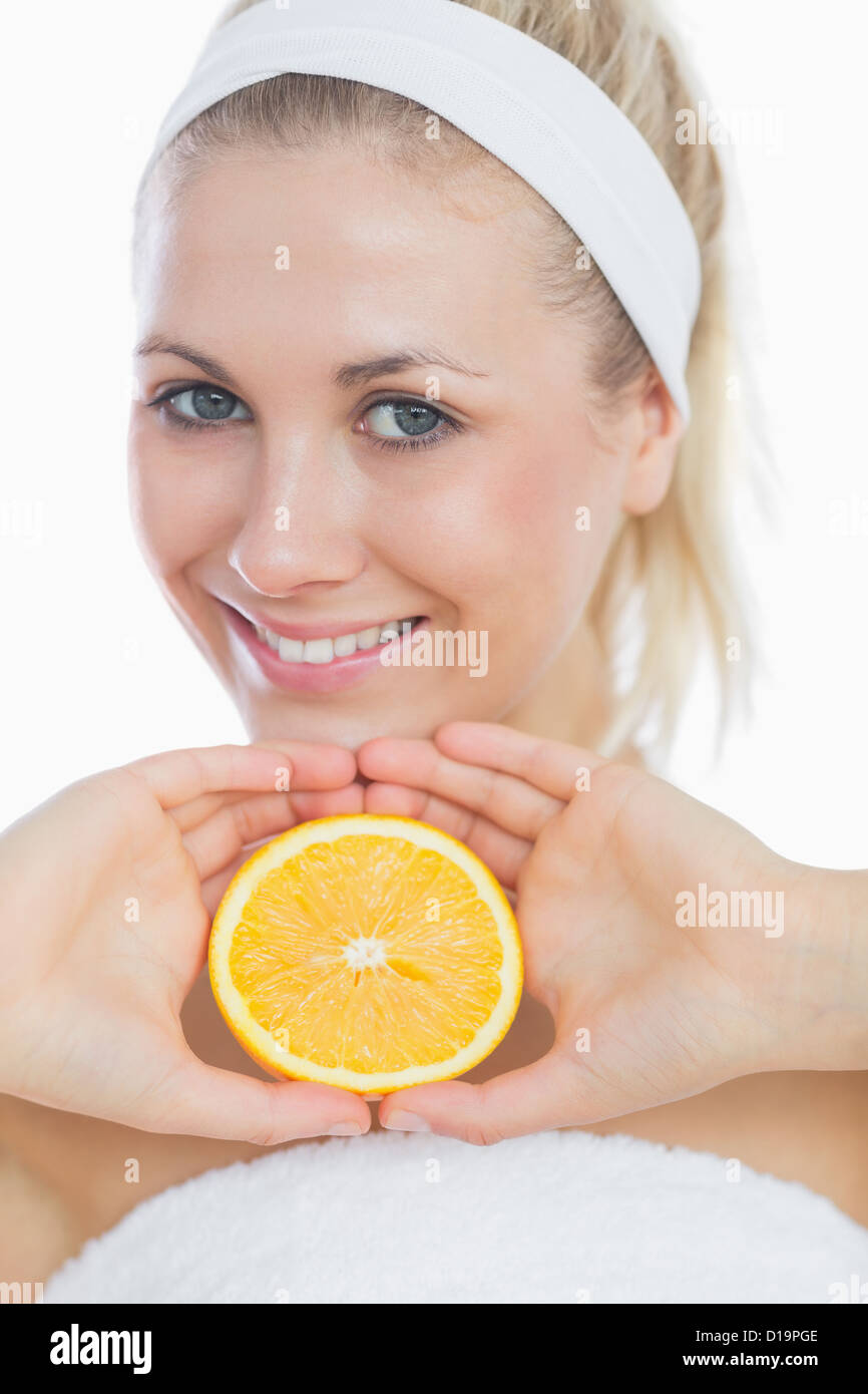 Happy young woman holding slice of orange Stock Photo - Alamy