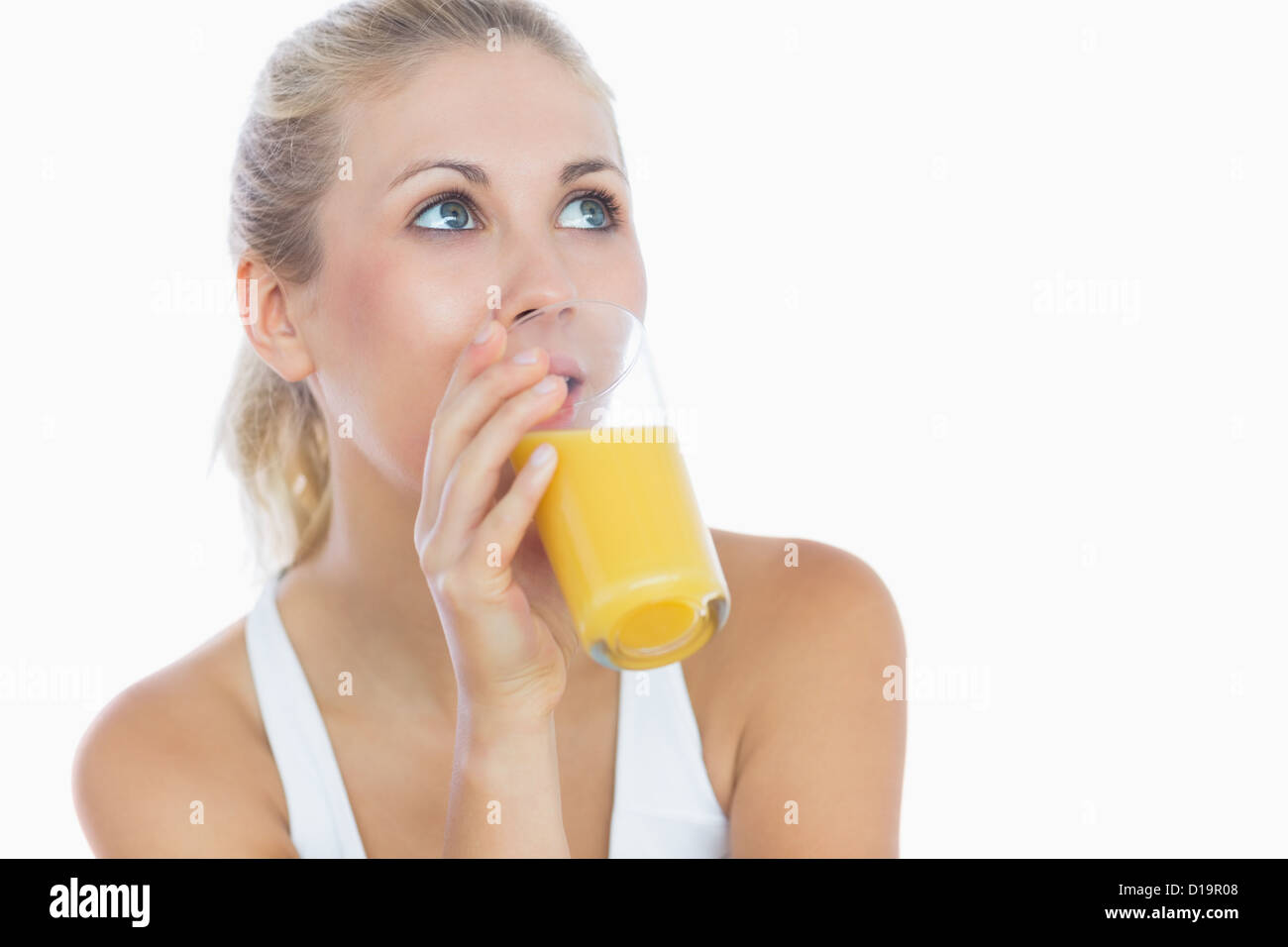 Woman drinking orange juice as she looks up Stock Photo Alamy