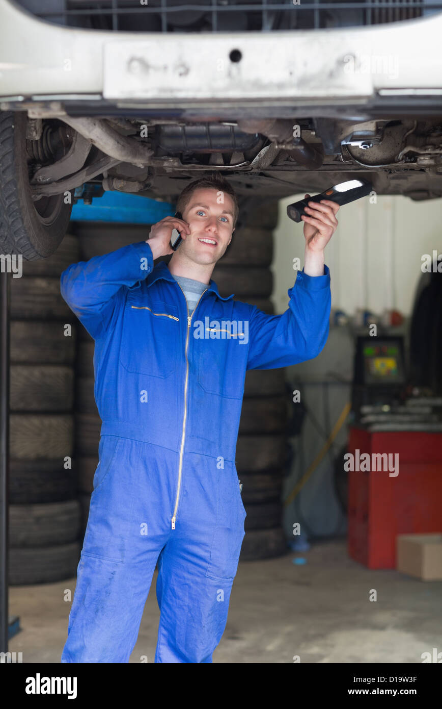 Auto mechanic using cell phone Stock Photo
