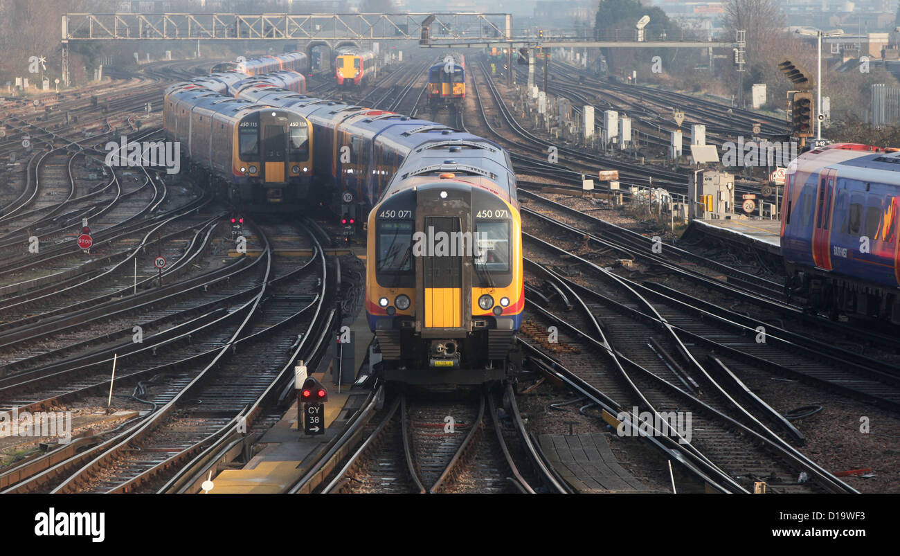 Trains approach and depart from Clapham Junction station in London. Stock Photo
