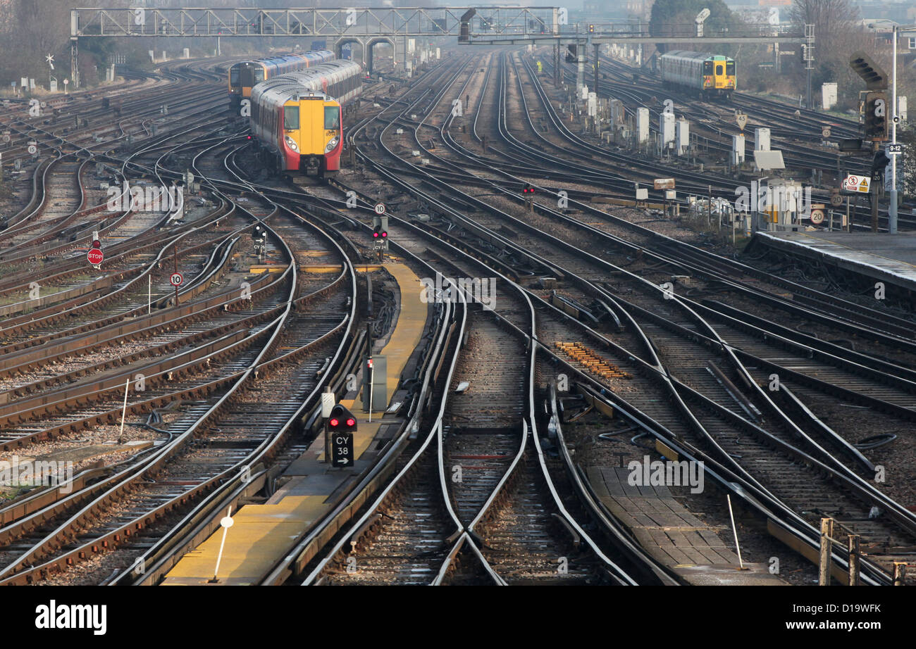 Trains approach and depart from Clapham Junction station in London. Stock Photo