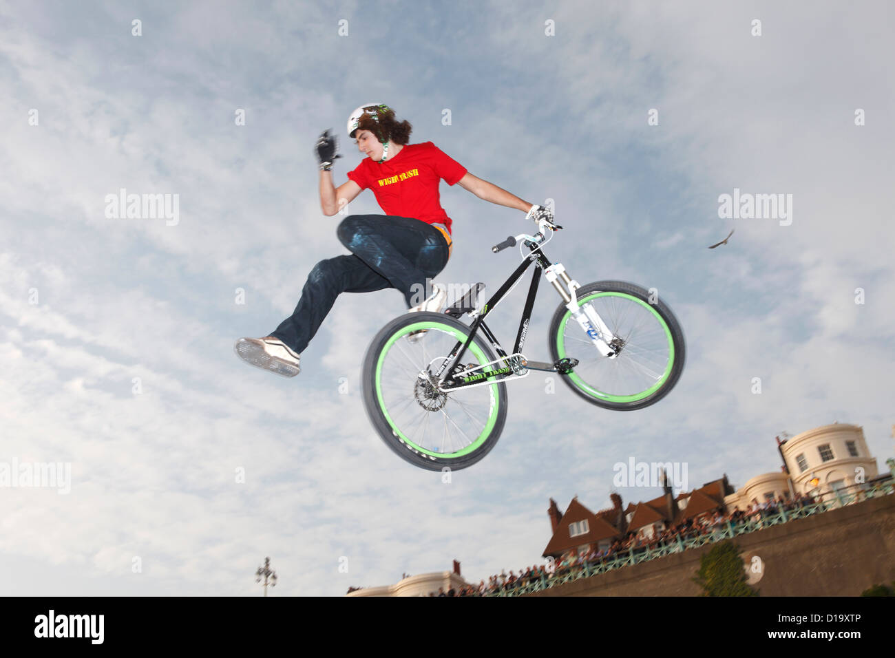 BMX Biker pulls off a trick while flying through the air after jumping off a kicker at the White Air festival, Brighton, UK. Stock Photo