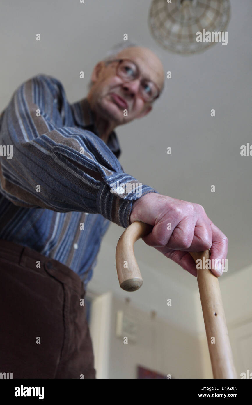 Elderly Caucasian man at home , managing mobility with walking stick, Suffolk, UK Stock Photo