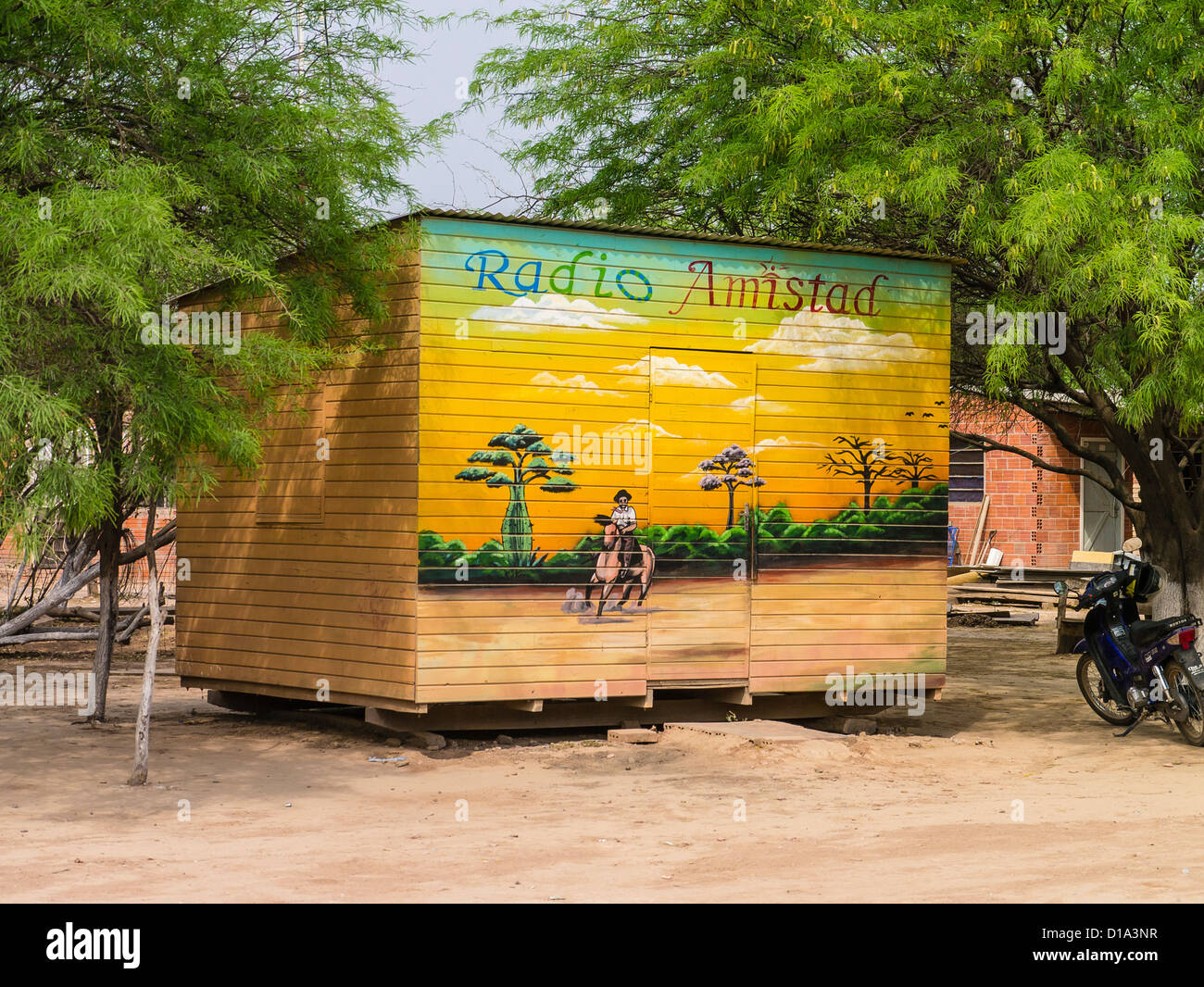 The side of a small radio station building painted with a colorful landscape scene in the city  Filadelfia, Paraguay. Stock Photo
