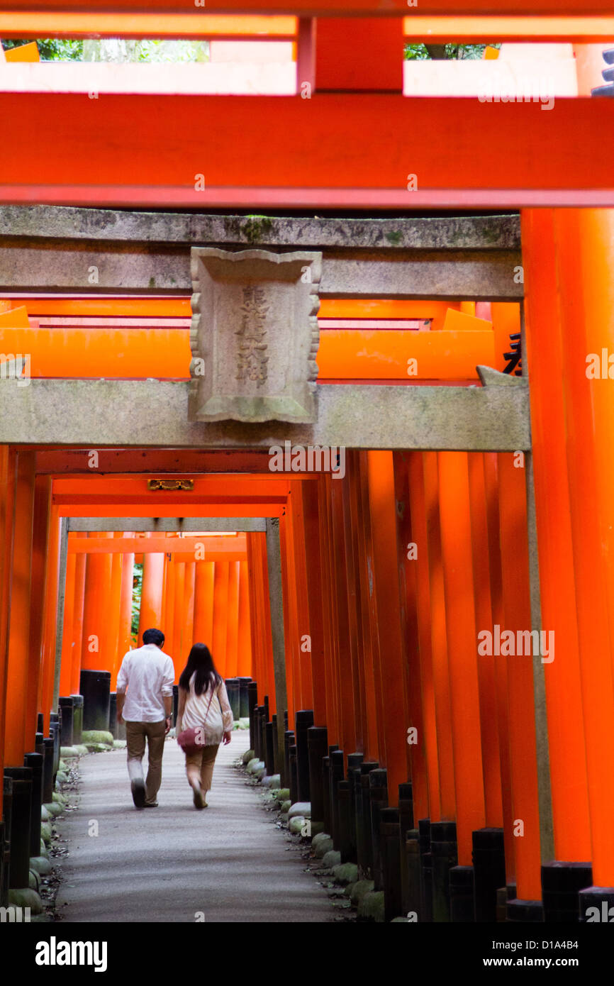 KYOTO, JAPAN A couple walks through a tunnel of wooden torii at the ...
