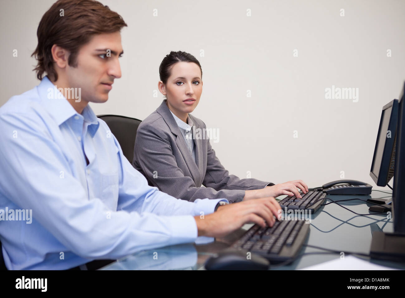 Colleagues using computers at office Stock Photo - Alamy