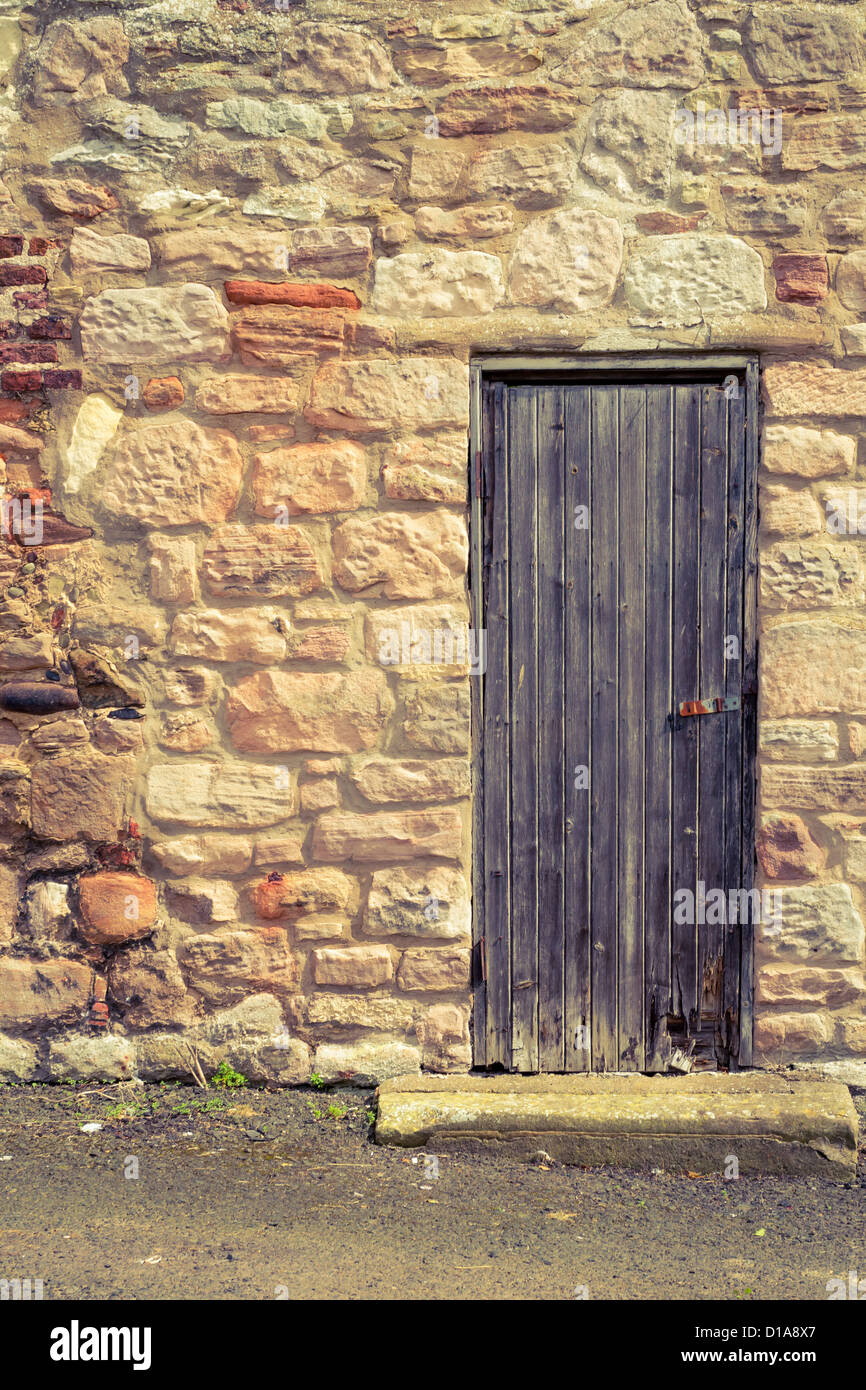 Old vintage wooden door in stone wall Stock Photo - Alamy